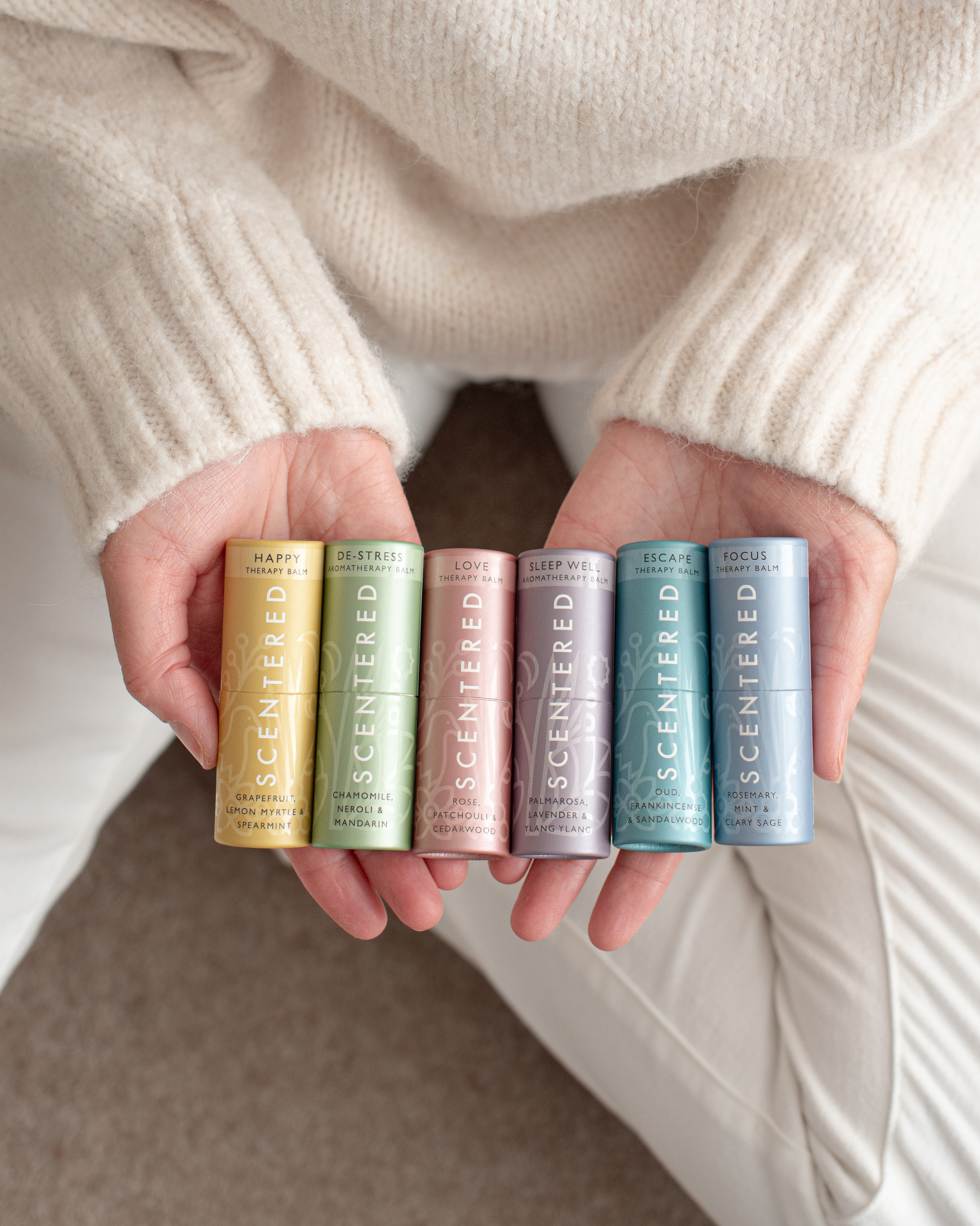 Hands holding a collection of Scentered aromatherapy balms